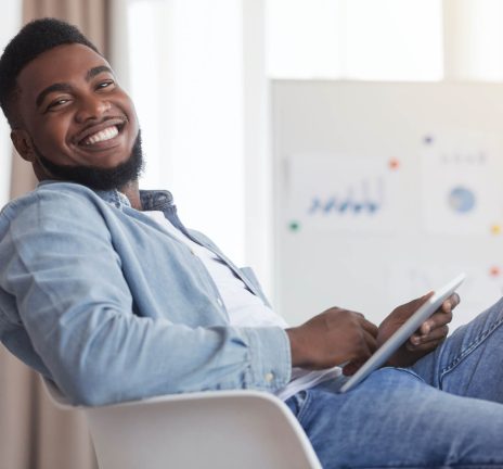 smiling-african-american-guy-sitting-at-work-with-2021-08-26-16-34-01-utc