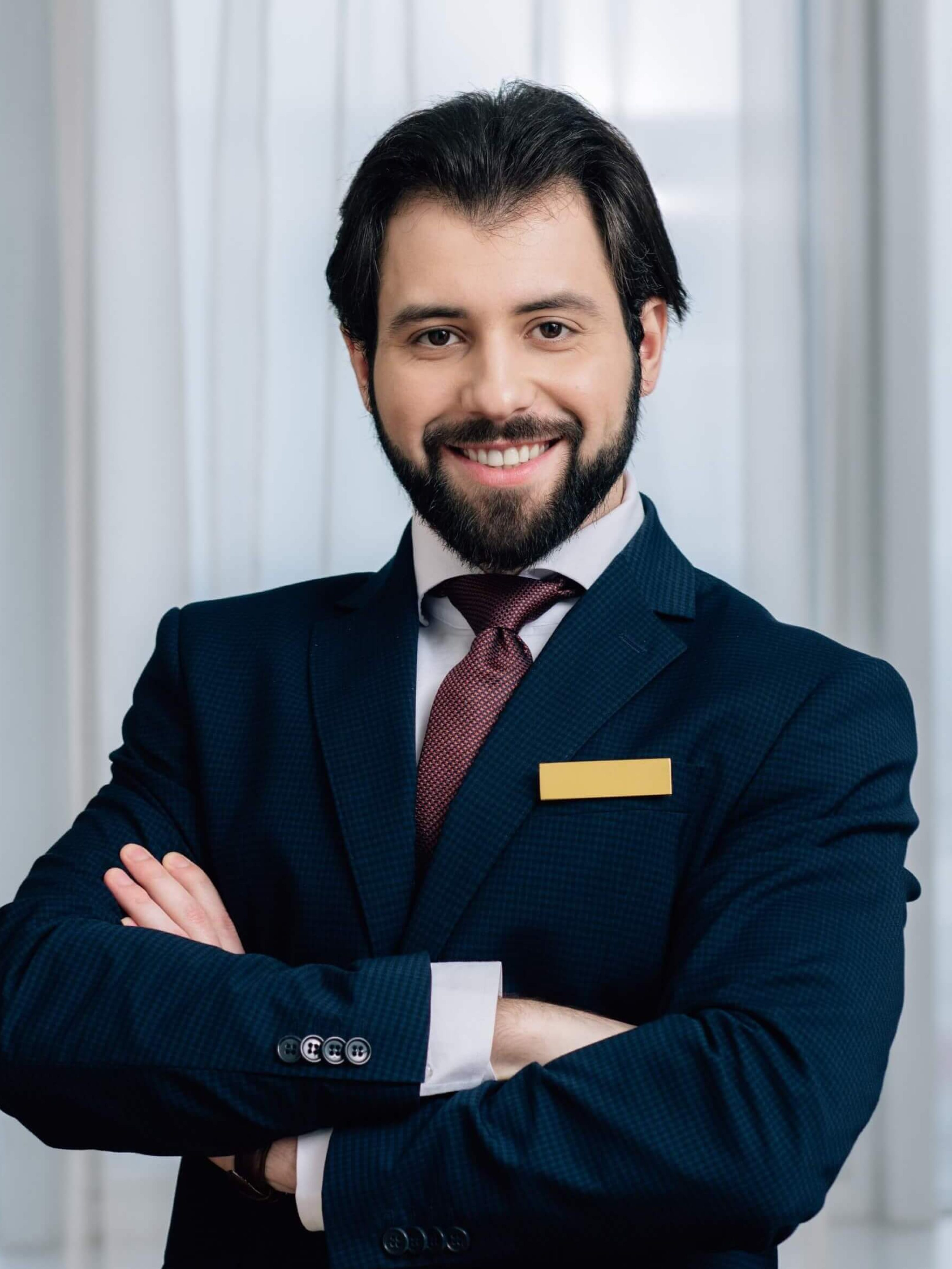handsome-hotel-administrator-with-crossed-arms-loo-2024-11-17-13-39-25-utc