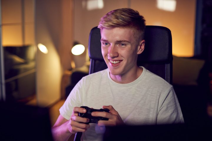 teenage-boy-with-game-pad-sitting-in-chair-and-gam-2024-10-19-10-32-46-utc